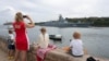 Miembros de la comunidad rusa en Cuba observan la entrada de la fragata Almirante Gorshkov a la bahía de La Habana, desde el Malecón. (REUTERS/Alexandre Meneghini)