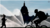 ARCHIVO - El Capitolio se ve mientras los rociadores de agua empapan el National Mall en una calurosa mañana de verano en Washington, el 15 de julio de 2022.