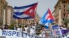 Miembros de la comunidad cubana en Italia ondean banderas del país y cantan consignas contra el presidente de Cuba, Miguel Díaz-Canel durante su visita al Vaticano. (AP/Domenico Stinellis)