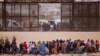 Foto Archivo. Migrantes se paran cerca del muro fronterizo después de cruzar el río Bravo con la intención de entregarse a los agentes de la Patrulla Fronteriza de los Estados Unidos. REUTERS: Jose Luis Gonzalez