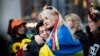 Dos mujeres envueltas en una bandera ucraniana se abrazan durante un flash mob el 8 de abril en Nueva York, en protesta por el abuso sexual de soldados rusos en Ucrania. (AFP/Kena Betancur).