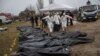 Forenses trasladan el cuerpo de un civil asesinado durante la guerra con Rusia tras sacarlo de una fosa común en Kyiv, Ucrania, el 8 de abril. (AP/Rodrigo Abd)