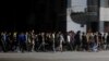 Agentes de civil con palos avanzan hacia los manifestantes de una protesta pacífica en La Habana, durante un apagón, el 30 de septiembre de 2022.