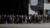 Agentes de civil con palos marchan y gritan consignas progubernamentales después de una protesta durante un apagón el 30 de septiembre de 2022.
