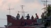 Cubanos observan como se llevan a un grupo de personas sospechosas del estar contagiadas con COVID-19.
