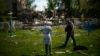 Residentes de pie junto a una escuela destrozada en un ataque ruso en Bakhmut, en el este de Ucrania. (AP Foto/Francisco Seco)