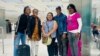 El pastor Alain Toledano con su familia y (centro) la miembro del personal de OAA Sumaya Dávila, en el Aeropuerto Internacional de Miami. (Foto: Facebook/OAA)