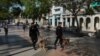 Boinas negras con perros recorren el Paseo del Prado en el primer aniversario del estallido del 11 de julio.