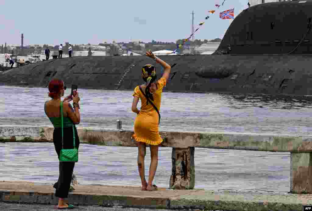 Una mujer saluda a los miembros de la tripulación del submarino de propulsión nuclear Kazán, parte del destacamento naval ruso que visita Cuba, después de su llegada al puerto de La Habana el 12 de junio de 2024. YAMIL LAGE / AFP