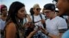 Cubanos verifican conexión a internet en sus móviles durante una prueba de ETECSA.