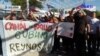 Migrantes llevarán rosas durante una marcha a agentes fronterizos