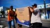 Armando Sánchez (der.) carga una nevera adquirida en una de las nuevas tiendas recuadadoras de divisas en La Habana. (REUTERS/Alexandre Meneghini)
