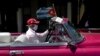 Un taxista privado transporta turistas por La Habana portando una máscara protectora por el coronavirus.