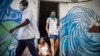 Dos trabajadores de salud provistos de mascarilas se retiran de un inmueble en La Habana tras verificar que la zona esta libre de COVID-19. (AP/Ramón Espinosa)