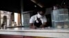 Una empleada espera por clientes en un local de venta de alimentos, en La Habana, el 24 de marzo del 2020.