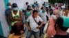Personas esperan para comprar en un mercado mayorista en La Habana.