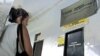 Una cubana espera afuera de una oficina de Western Union para cobrar dinero de familiares en EE.UU.