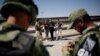 Un agente del Instituto Nacional de Inmigración (INM) habla con los cubanos luego de ser detenidos por la Guardia Nacional de México mientras intentaban cruzar ilegalmente la frontera entre los Estados Unidos y México, en Ciudad Juárez.