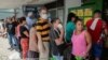 La gente espera en fila para comprar comida en un supermercado de La Habana.