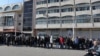 Los sirios esperan en fila afuera de un edificio oficial para resolver su situación con las nuevas autoridades del país, en Tartus, en el oeste de Siria, el 17 de diciembre de 2024.