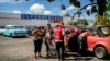 Cubanos descargan en sus autos alimentos y otros productos adquiridos en un mercado en dólares en La Habana.