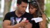Dos jóvenes usan un teléfono móvil en La Habana. (Archivo)