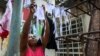 Una mujer tiende nasobucos preparados por ella misma para distribuir entre vecinos del Vedado (Foto: Adalberto Roque/AFP).