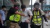 Paramédicos ayudan a un manifestante alcanzado por gas lacrimógeno durante una protesta en Causeway Bay, Hong Kong. (AP/Vincent Yu)