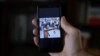 Un hombre que no quiso ser identificado muestra en su teléfono al rapero contestatario Maykel Castillo El Osorbo. (REUTERS/Alexandre Meneghini)