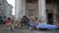 Dos hombres cuya vivienda fue severamente afectada por el huracán Irma conversan junto a sus pertenencias el jueves 21 de septiembre de 2017, en el malecón de La Habana (Cuba).