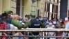 Policías controlando la población en una cola para conseguir alimentos, en La Habana.