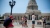 Turistas estadounidenses posan frente al Capitolio Nacional.