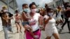 Una mujer con un niño en brazos marcha frente al Capitolio de La Habana durante una manifestación contra el presidente cubano Miguel Díaz-Canel en La Habana, el 11 de julio de 2021.