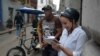 Una mujer se conecta a internet desde su celular en una calle de La Habana.