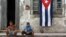 Dos niños posan frente a una casa en ruinas en Santiago de Cuba.