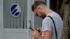 Un cubano se conecta a internet desde su celular en un punto WIFI de La Habana.
