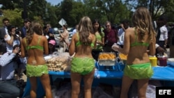 Activistas de PETA (Personas por un Trato Ético a los Animales) vestidas de lechuga, sirven perritos calientes vegetarianos a los transeúntes que pasan por la Casa Blanca de Washington DC, EE.UU. el 11 de julio de 2012. Foto Archivo