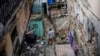 Mario Luis Poll habla con un vecino dentro de la mansión en ruinas en la calle Villegas en La Habana. (Foto AP/Ramón Espinosa)